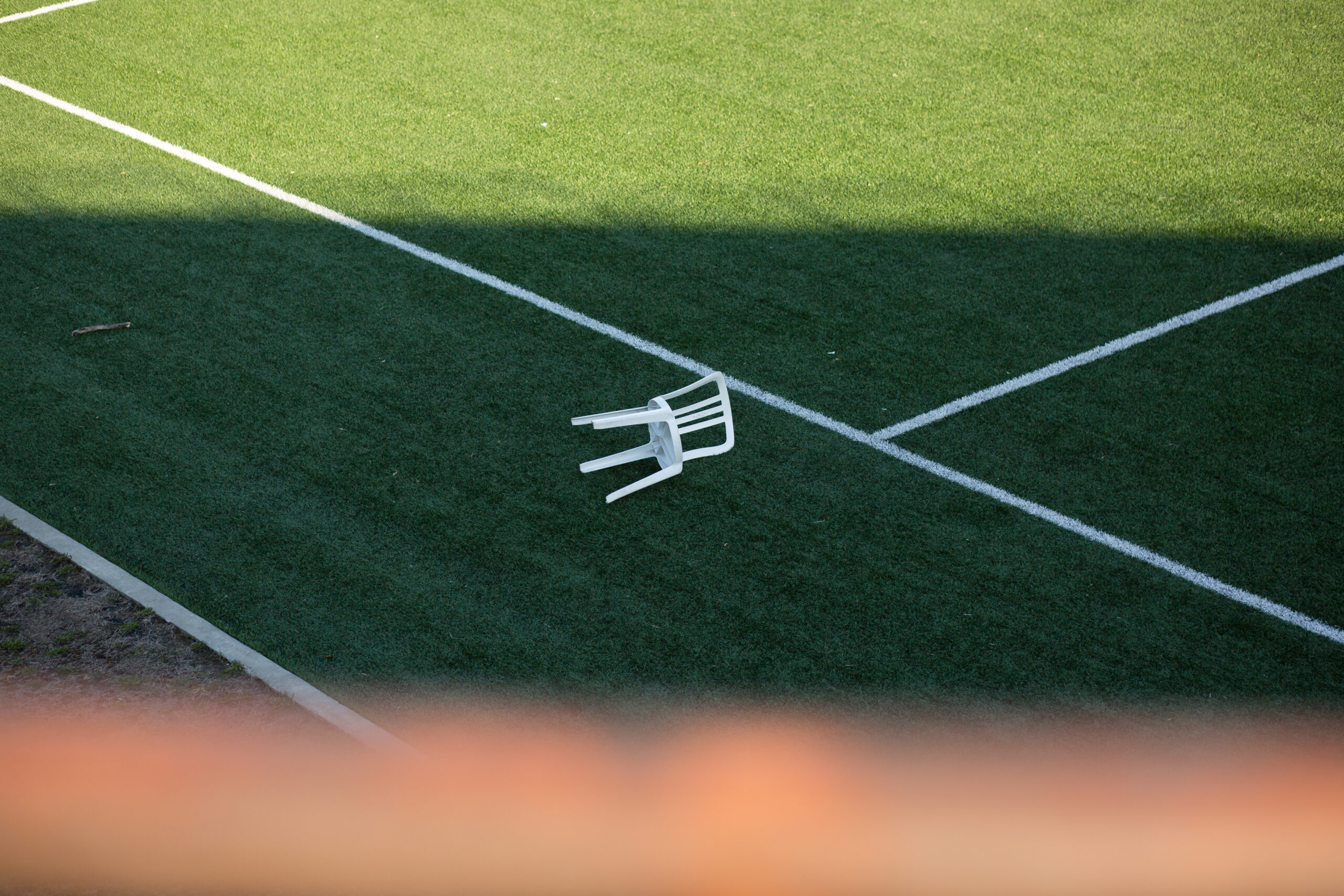 Une chaise renversée sur un terrain de soccer fermé, aux abords du Stade Saputo.